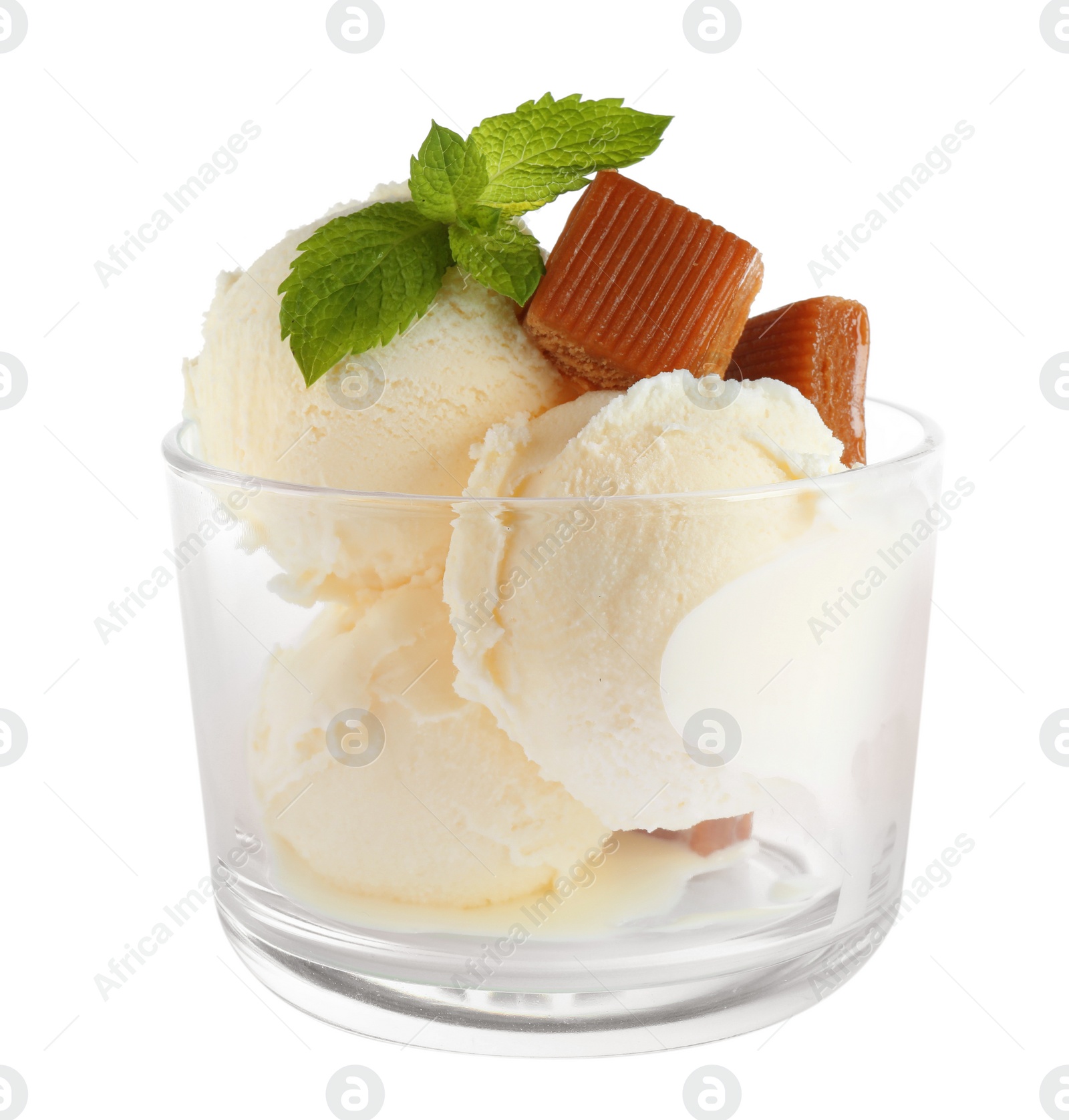 Photo of Glass of delicious ice cream with caramel candies and mint on white background