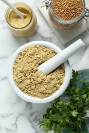 Photo of Mortar with aromatic mustard powder, grains and parsley on white marble table, flat lay