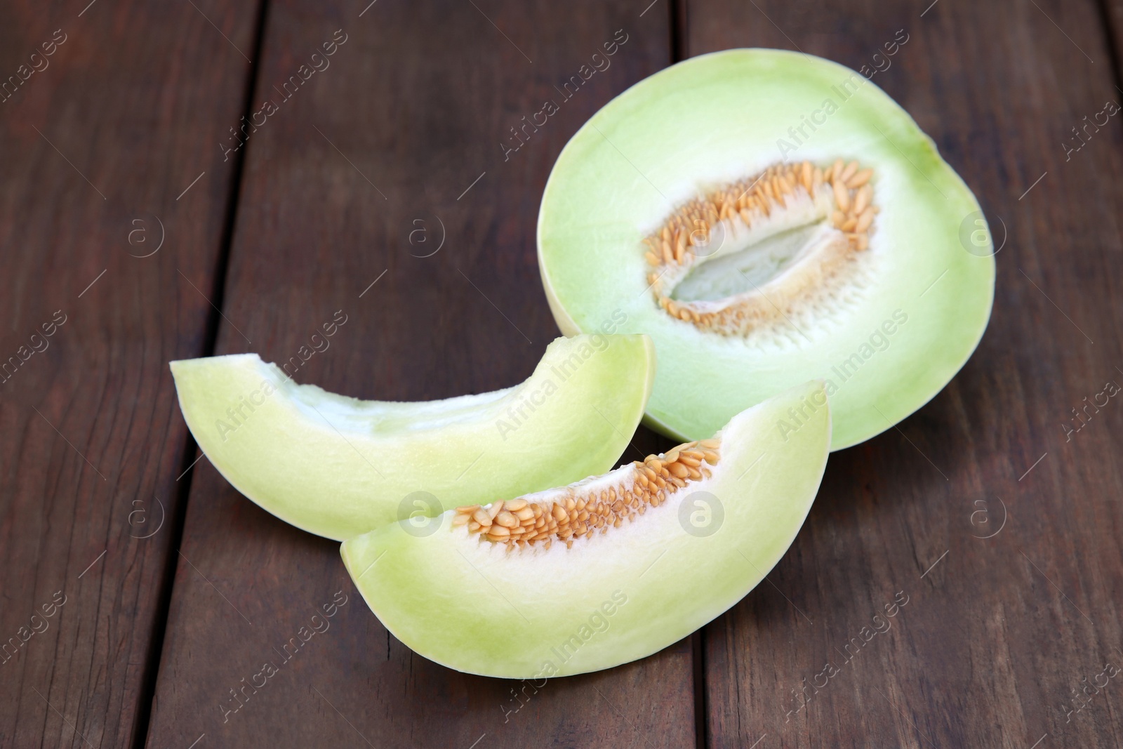 Photo of Cut tasty ripe melon on wooden table