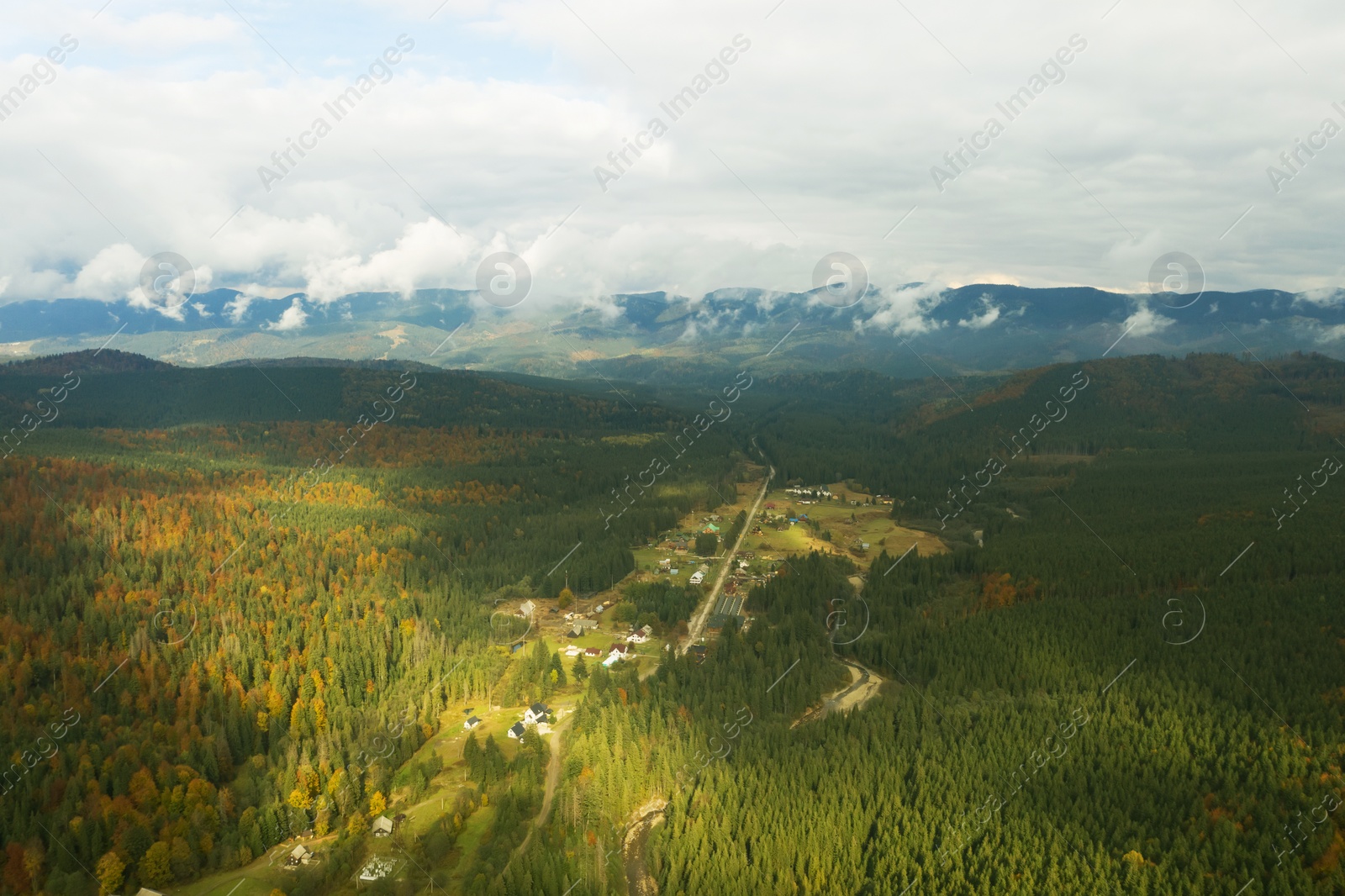 Image of Aerial view of beautiful forest and mountain village on autumn day