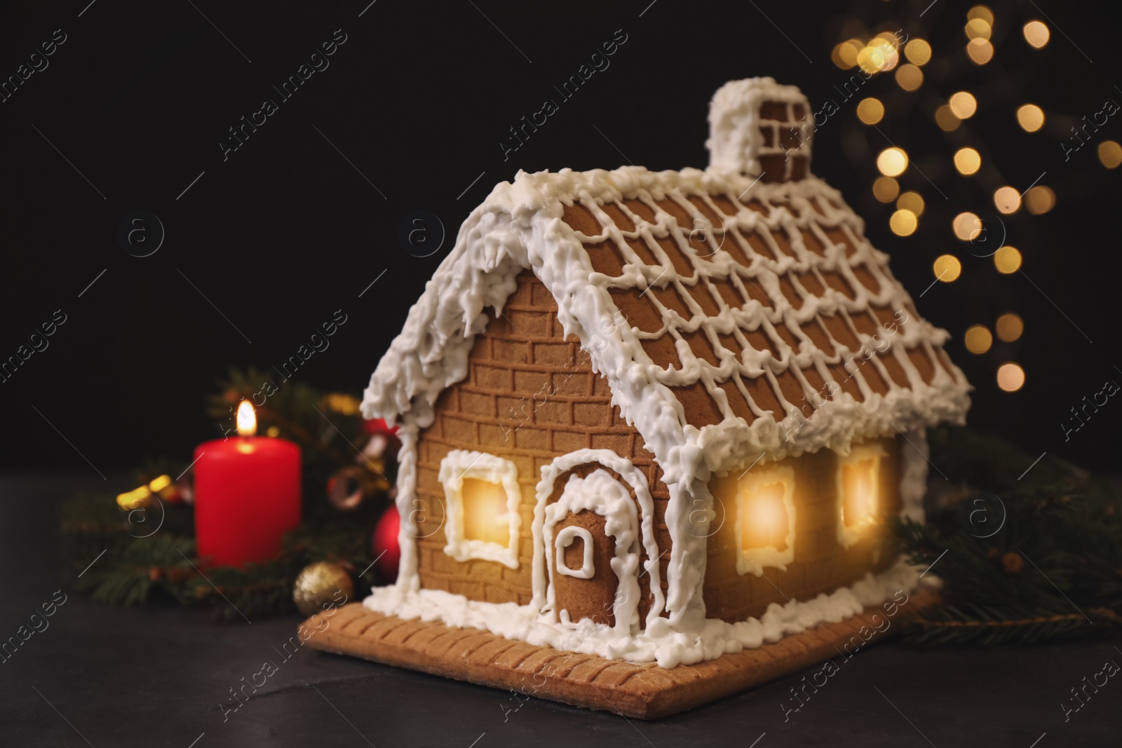 Photo of Beautiful gingerbread house decorated with icing on black table