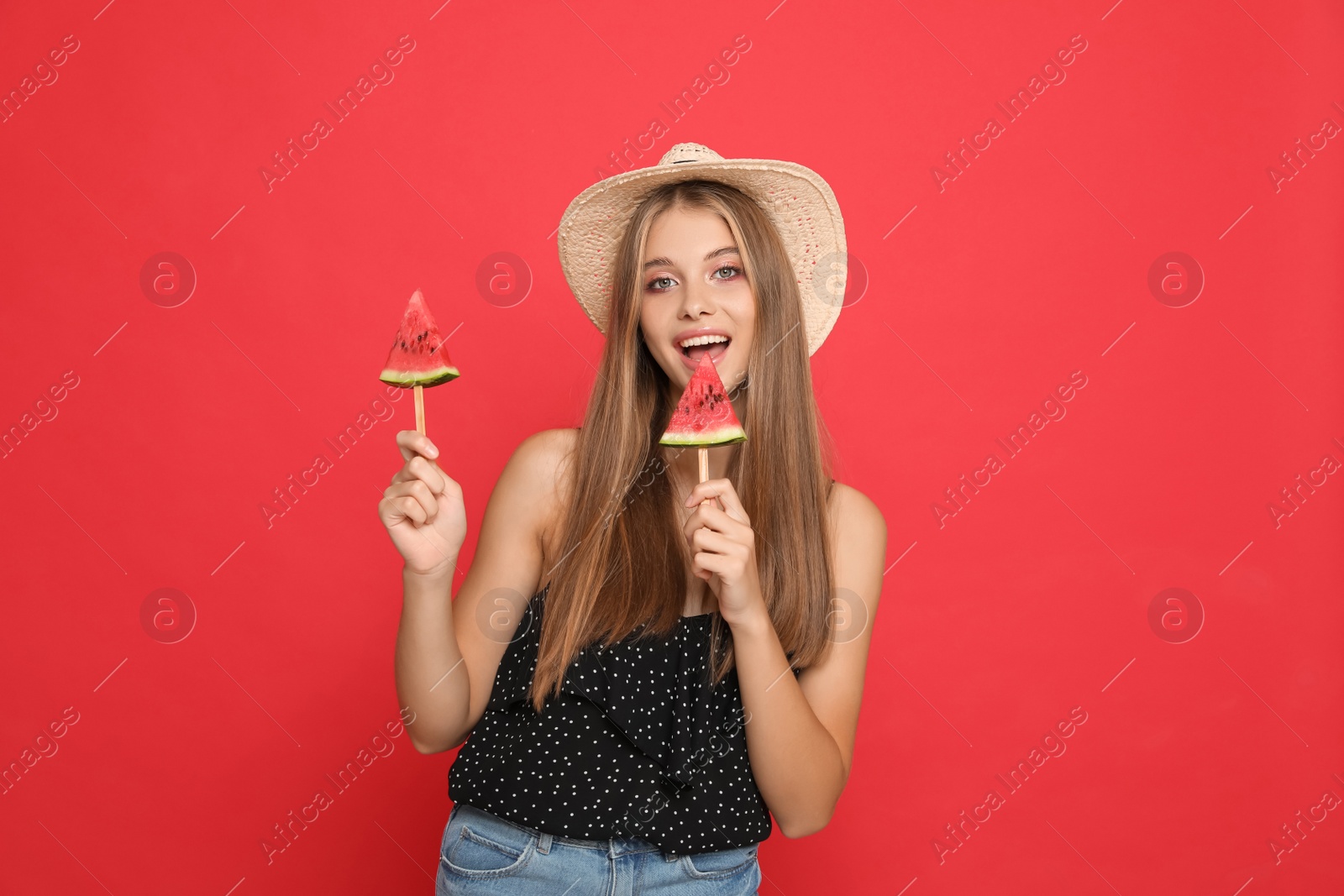 Photo of Beautiful girl with pieces of watermelon on red background