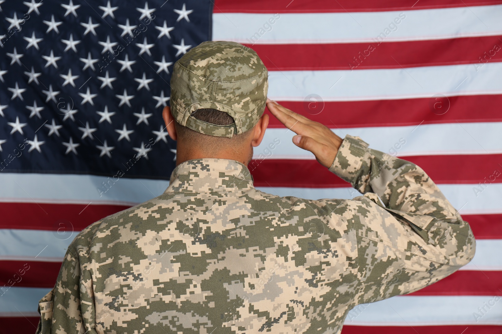 Photo of Soldier in uniform against United states of America flag, back view