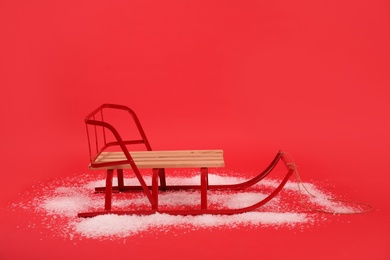 Empty sleigh and snow on red background