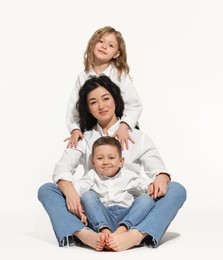 Photo of Little children with their mother on white background. Space for text