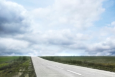 Photo of Blurred view of blue cloudy sky and asphalt road