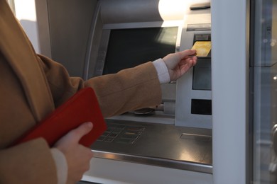 Photo of Young woman using cash machine for money withdrawal outdoors, closeup