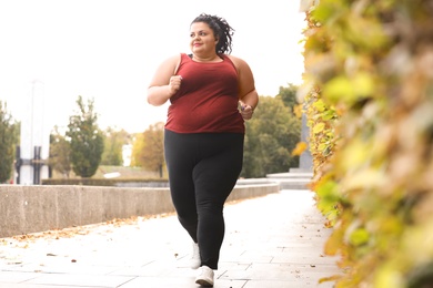 Beautiful overweight woman running in park. Fitness lifestyle