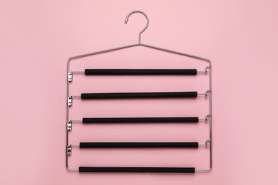 Photo of Empty hanger on pink background, top view