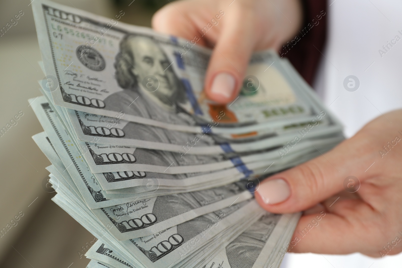 Photo of Money exchange. Woman counting dollar banknotes on blurred background, closeup