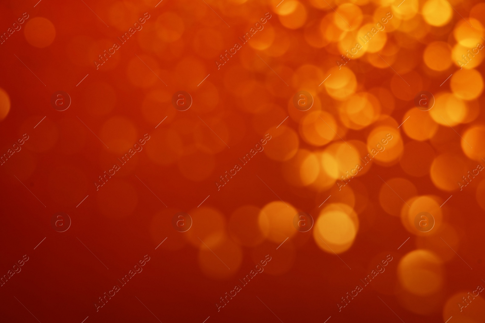 Photo of Blurred view of golden lights on red background. Bokeh effect