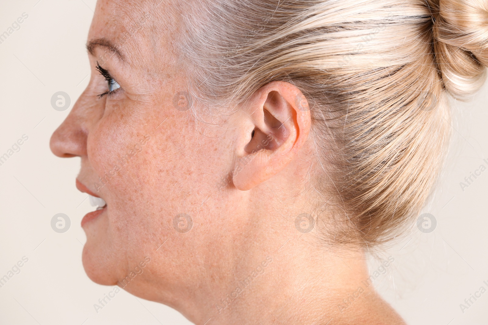 Photo of Mature woman on light background, closeup. Hearing problem