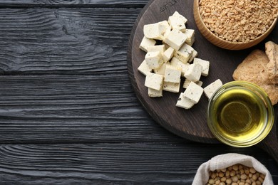 Photo of Different natural soy products on black wooden table, flat lay. Space for text