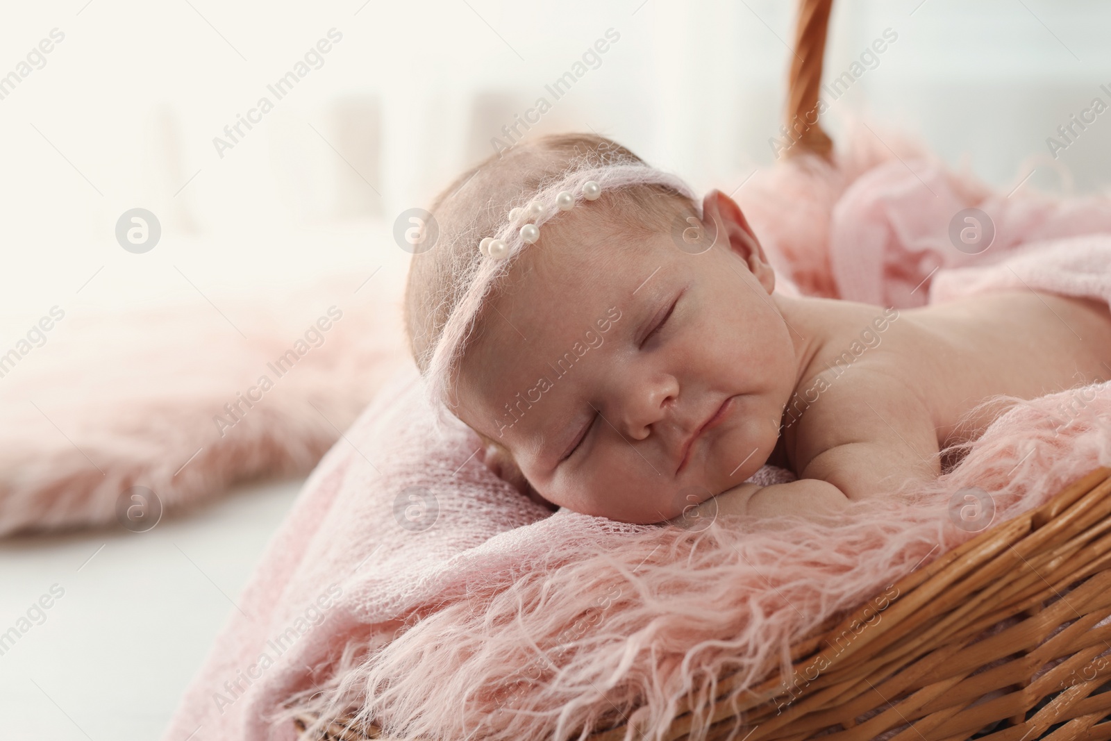 Photo of Adorable little baby sleeping in wicker basket at home