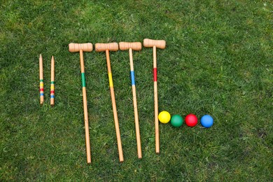 Set of croquet equipment on green grass, flat lay