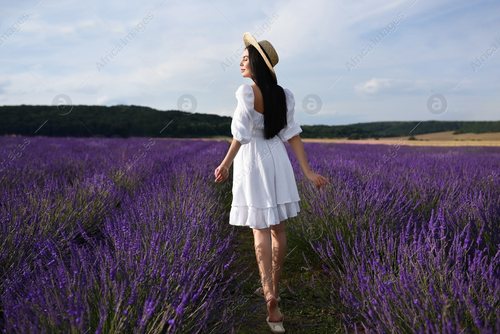 Photo of Beautiful young woman walking in lavender field