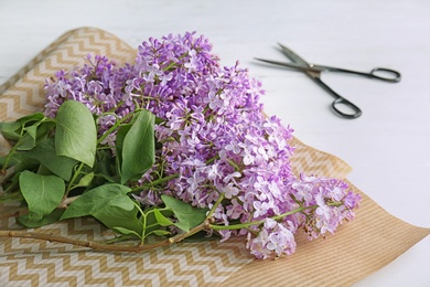 Photo of Beautiful blossoming lilac on table. Spring flowers