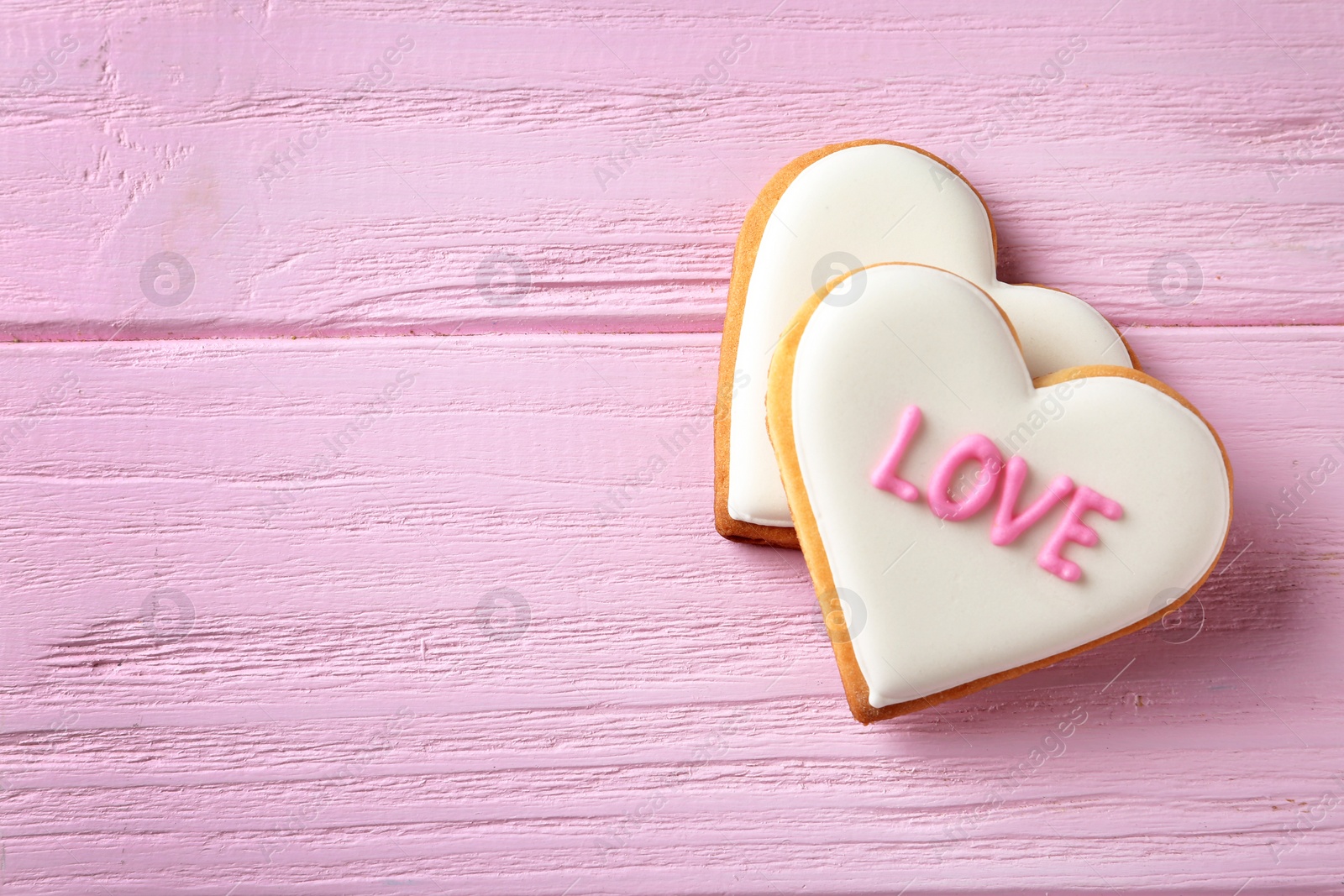 Photo of Decorated heart shaped cookies on wooden background, top view with space for text. Valentine's day treat