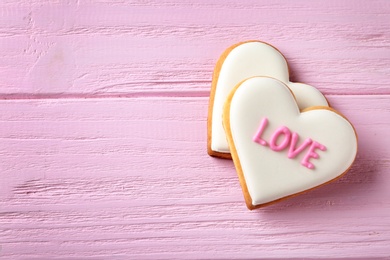 Photo of Decorated heart shaped cookies on wooden background, top view with space for text. Valentine's day treat