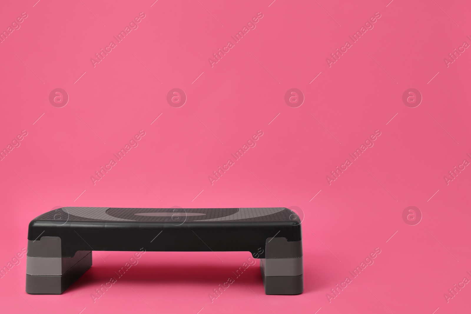 Photo of Step platform on pink background, space for text. Sports equipment