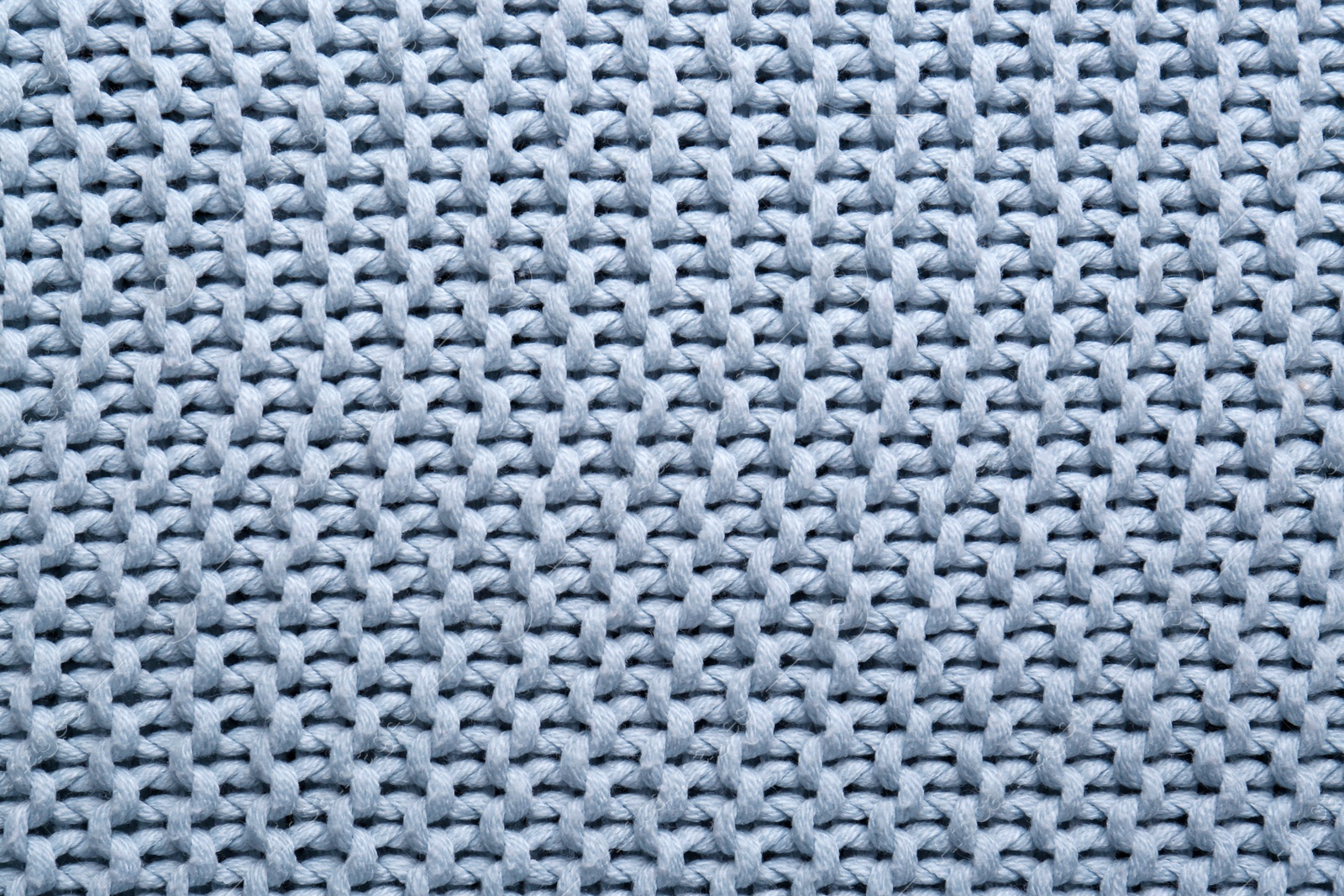 Photo of Beautiful light blue knitted fabric as background, top view