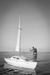 Image of Young man and his beautiful girlfriend in bikini on yacht. Black and white tone