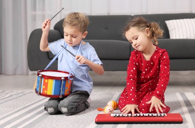 Photo of Little children playing toy musical instruments at home