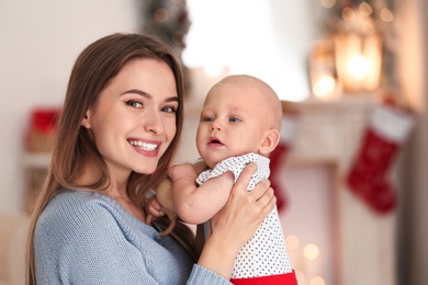 Photo of Happy mother with cute baby at home. Celebrating Christmas