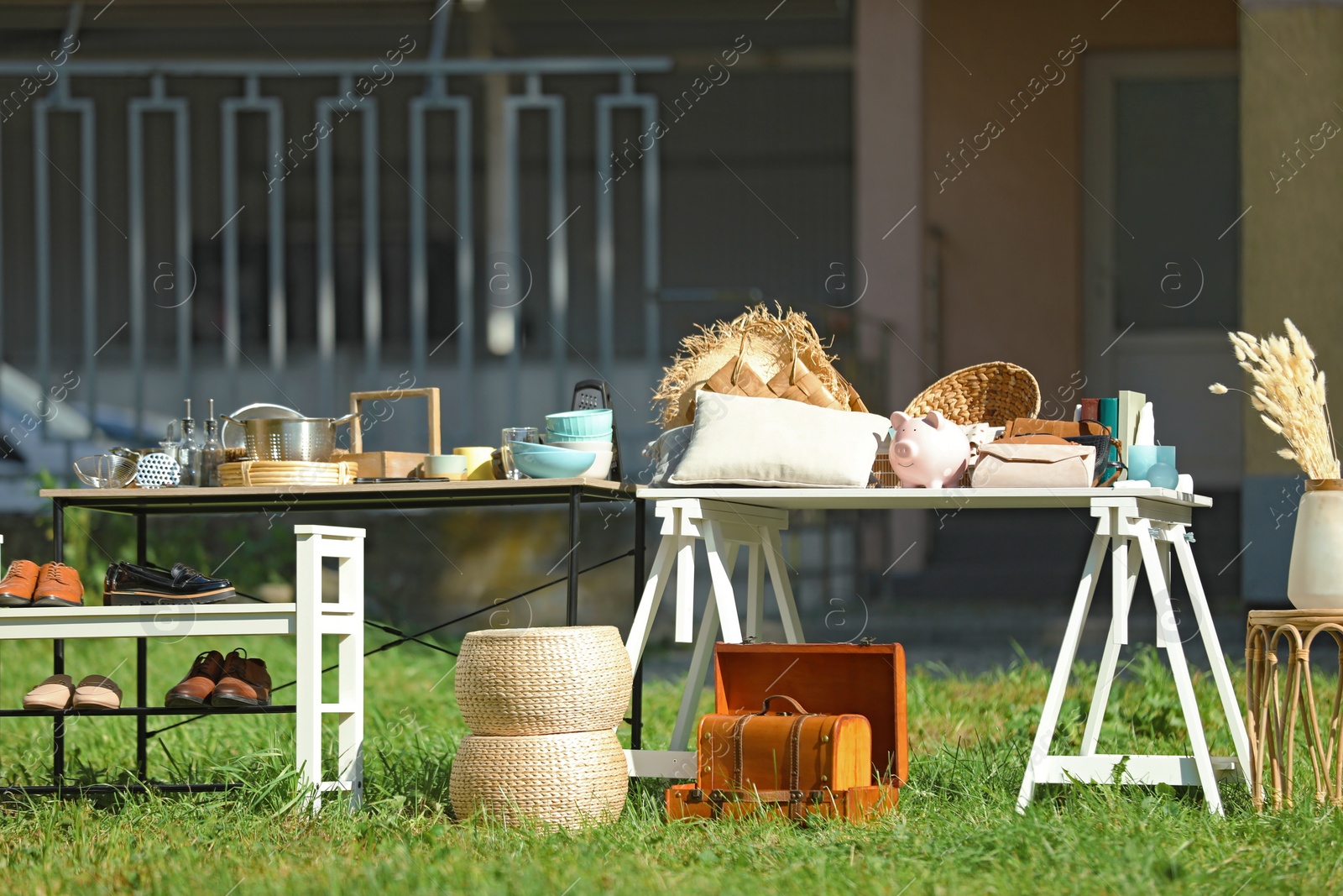 Photo of Small tables with many different items on garage sale in yard