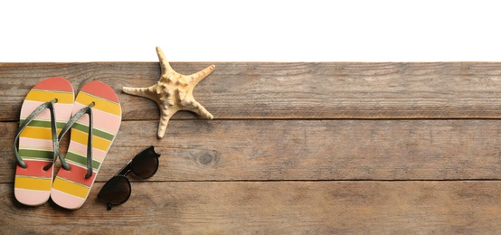 Photo of Shoes, sunglasses and starfish on wooden table, space for text. Beach accessories