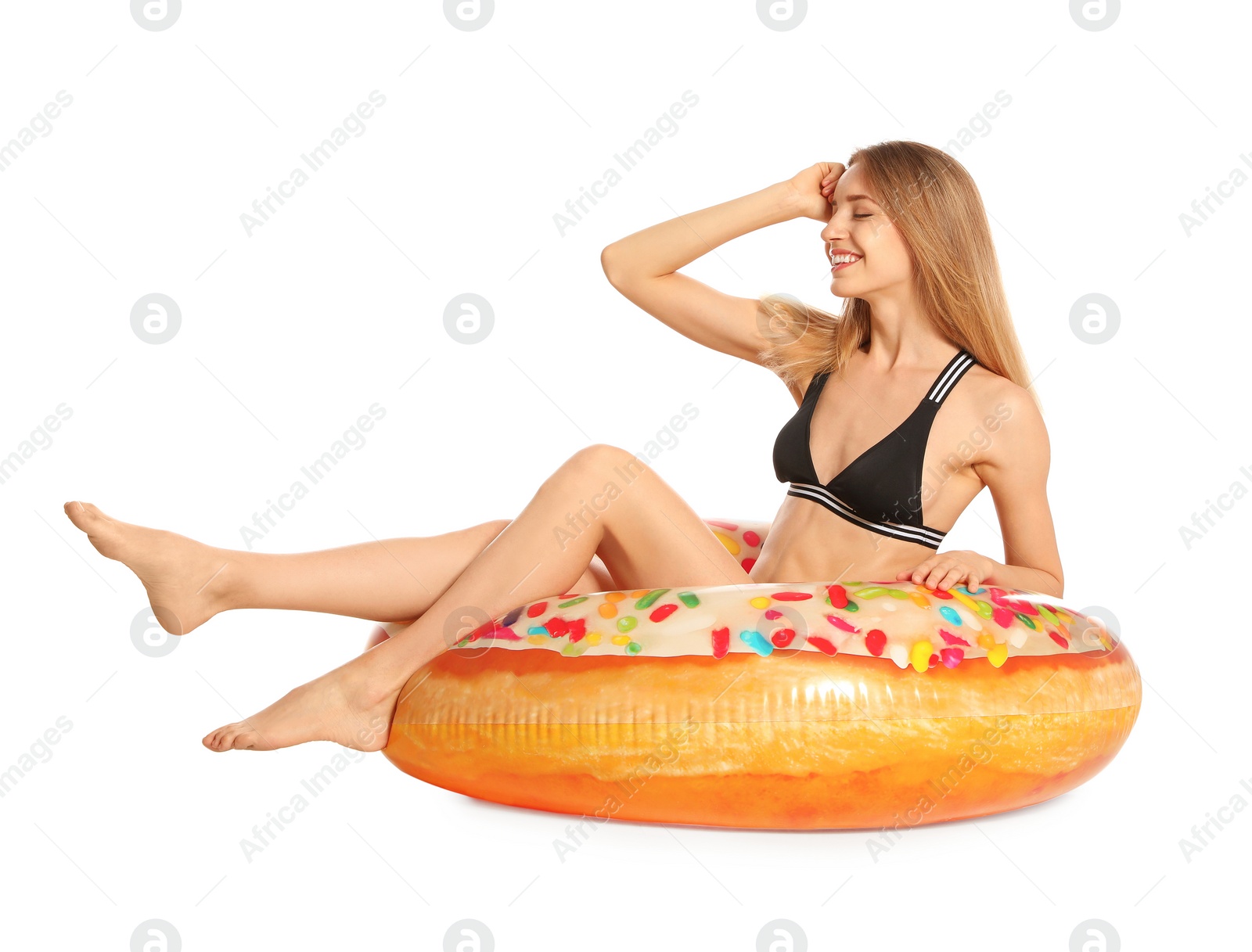 Photo of Beautiful young woman in stylish bikini with doughnut inflatable ring on white background