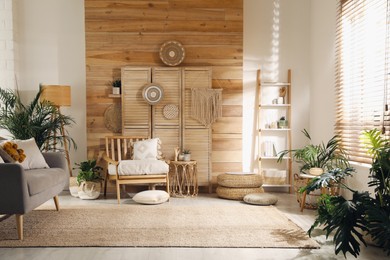 Photo of Stylish living room interior with comfortable wooden armchair and beautiful houseplants