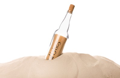 Photo of Corked glass bottle with Wishes note in sand on white background