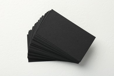 Photo of Blank black business cards on white table, top view