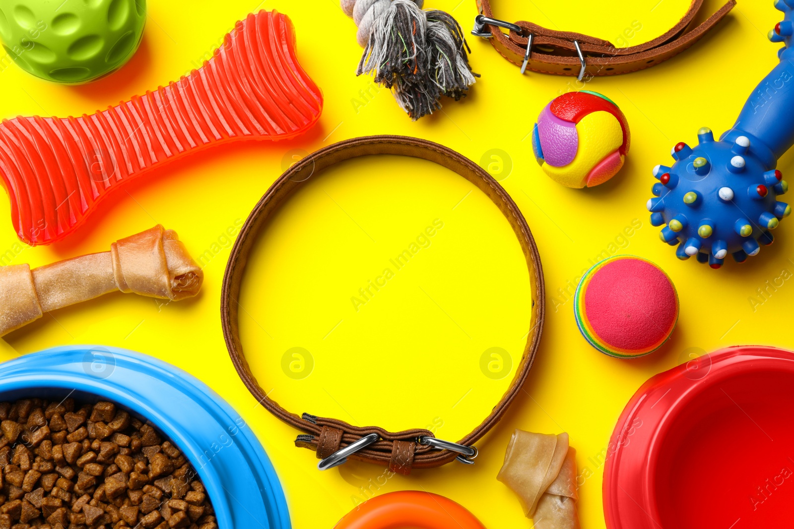 Photo of Flat lay composition with dog collar, toys and food on yellow background