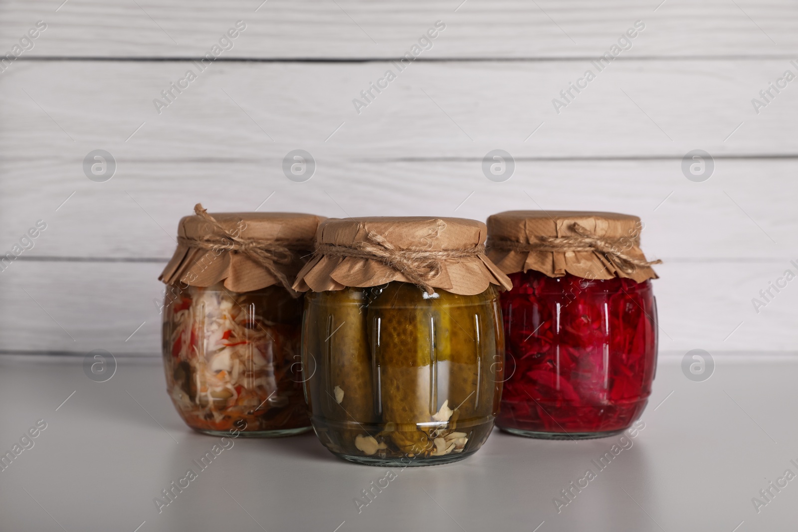 Photo of Jars with different preserved vegetables on light grey table