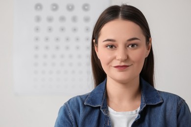 Photo of Portrait of young woman against vision test chart