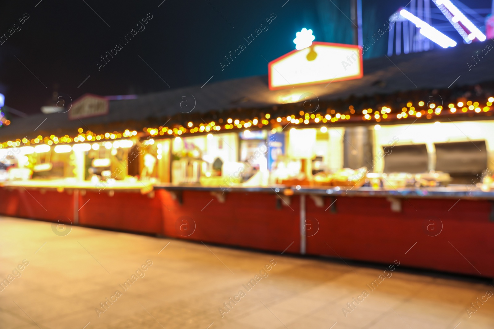 Photo of Blurred view of Christmas fair stalls outdoors at night