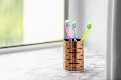 Photo of Cup with toothbrushes on table. Dental care