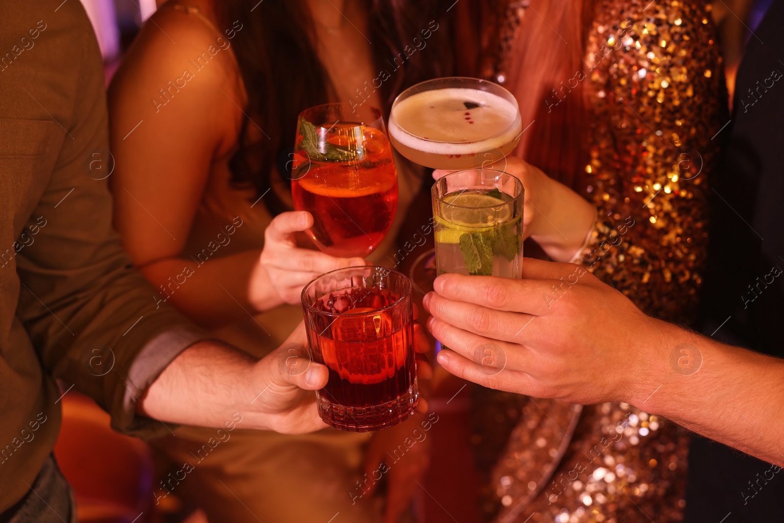 Photo of Friends clinking glasses with fresh cocktails, closeup