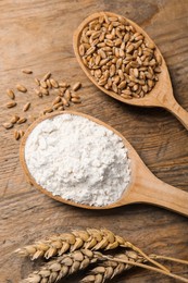 Photo of Spoons with wheat flour, grains and spikes on wooden table, above view