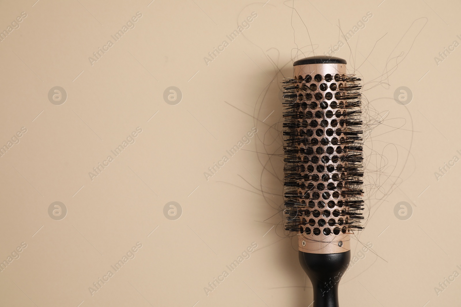 Photo of Professional brush with lost hair on beige background, top view. Space for text