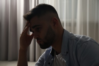 Photo of Sad young man near on blurred background