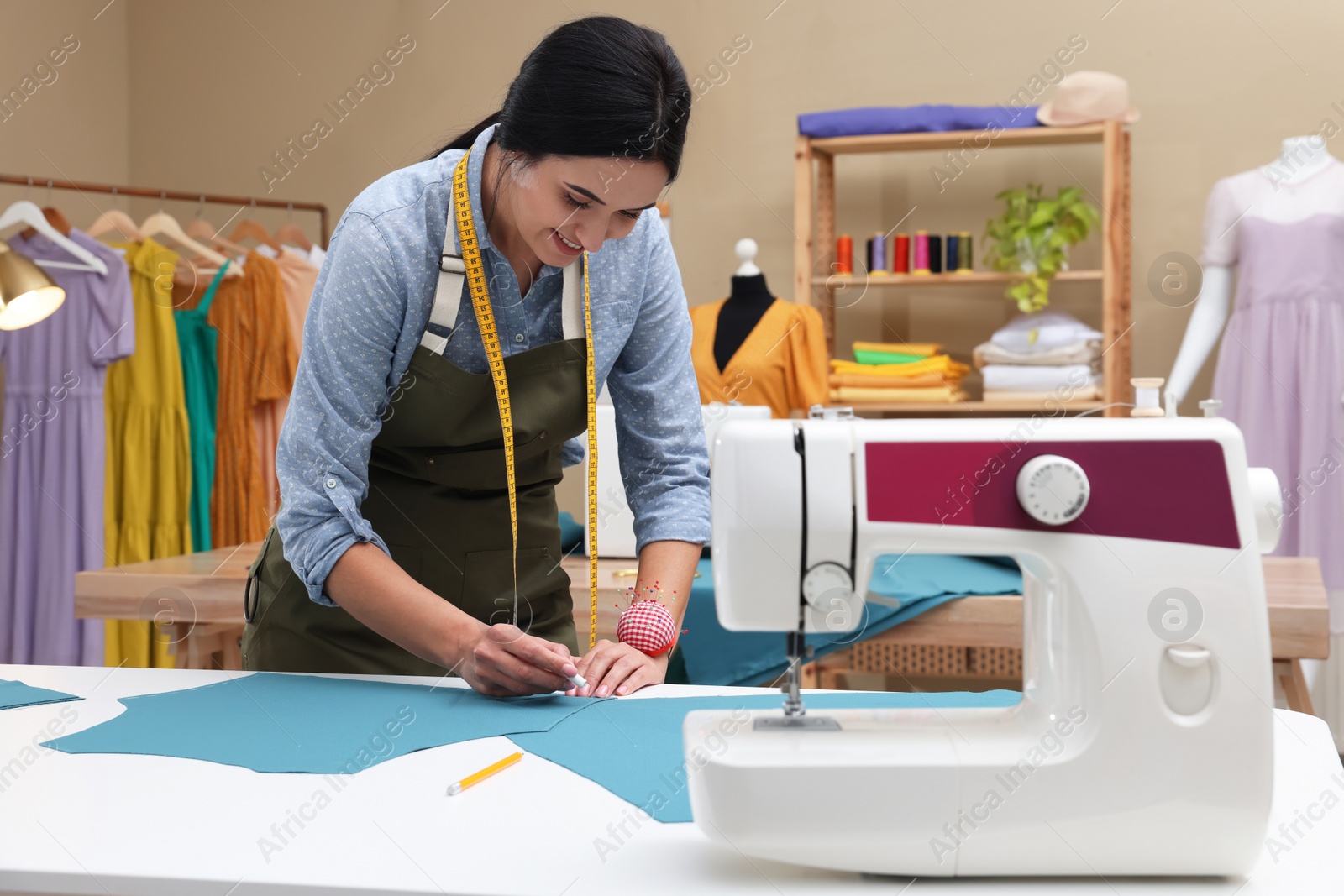 Photo of Dressmaker marking fabric with chalk in workshop