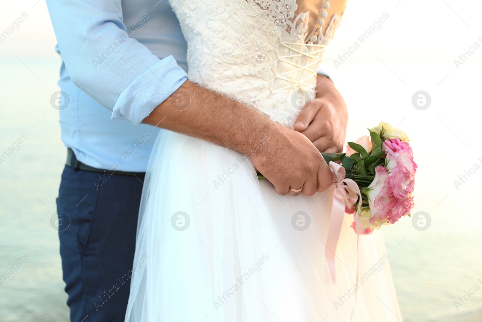 Photo of Wedding couple with beautiful bouquet on beach