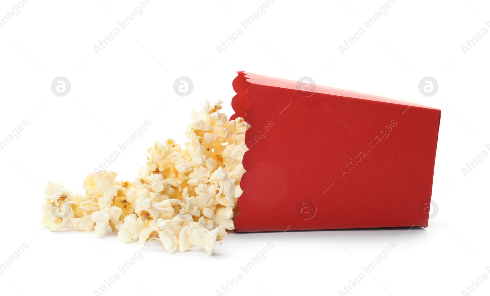 Photo of Overturned red bucket with delicious popcorn on white background