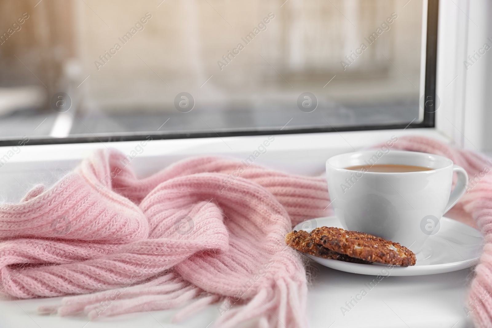 Photo of Cup of winter drink, cookies and knitted scarf on windowsill. Space for text