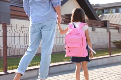 Photo of Father taking his little child to school on street