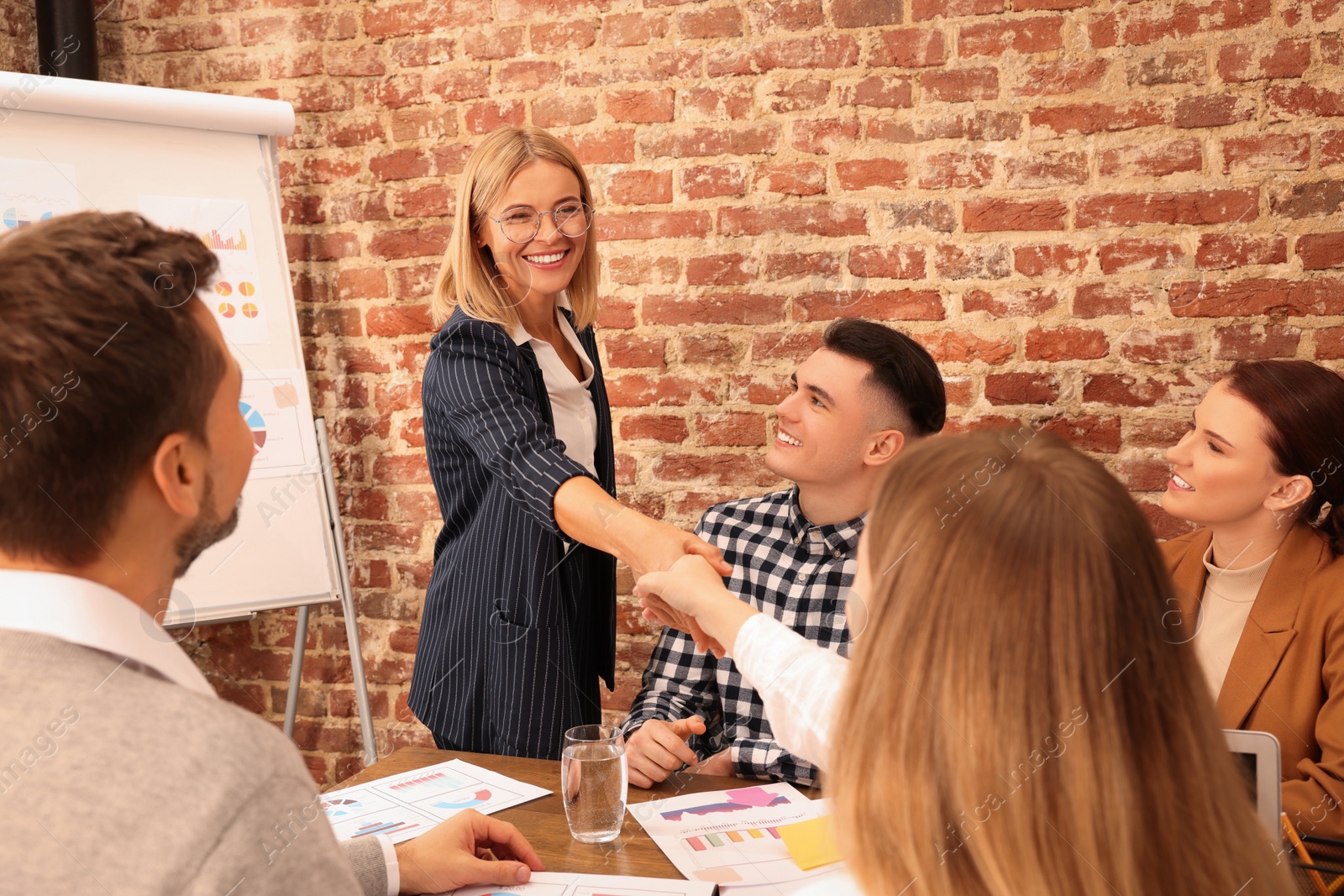 Photo of Businesswoman having meeting with her employees in office. Lady boss