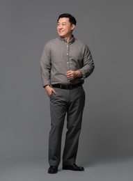 Photo of Full length portrait of happy businessman on grey background. Space for text
